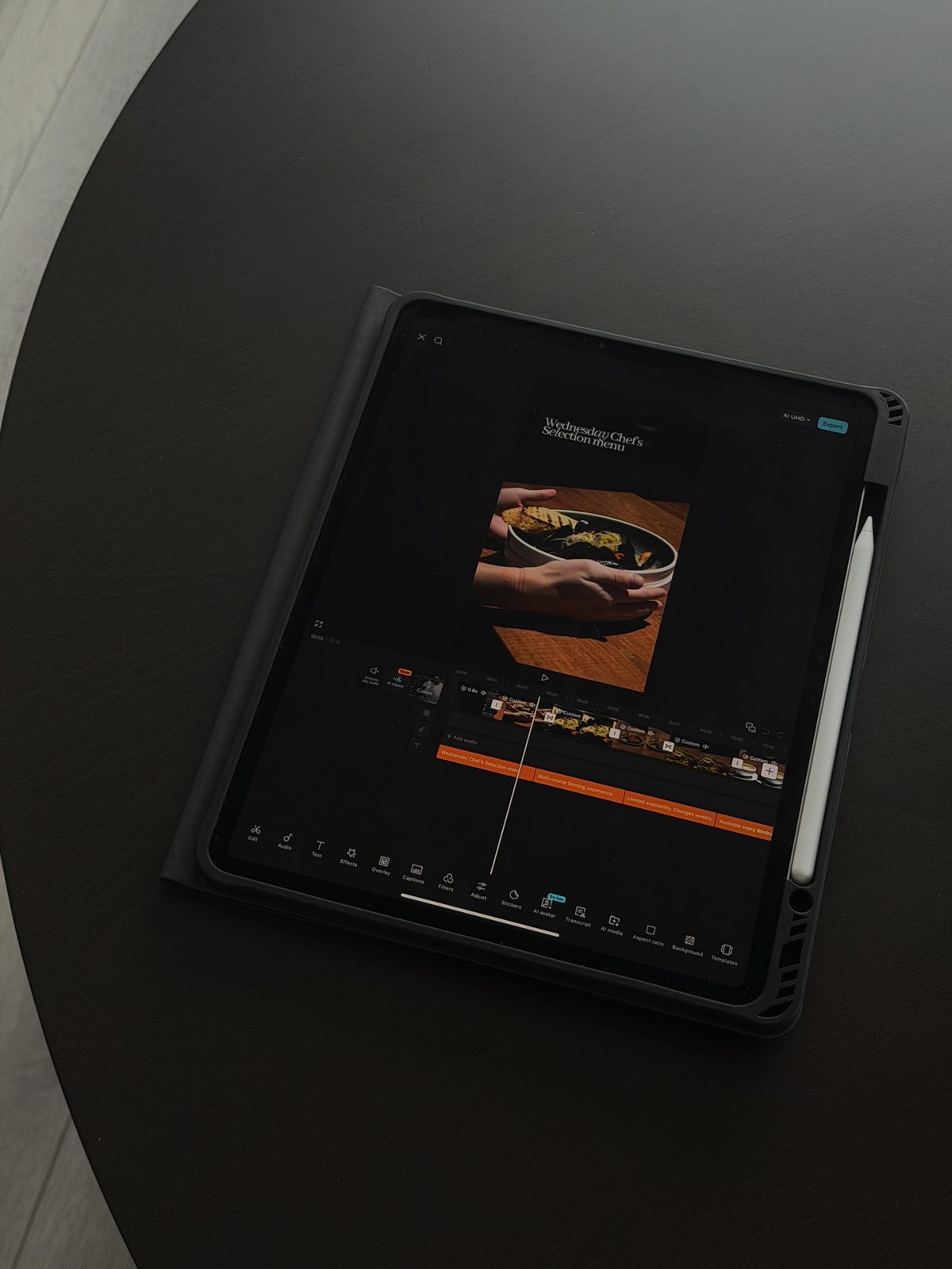 Editing the restaurant client's reel on an iPad in Noble Media's dark studio.